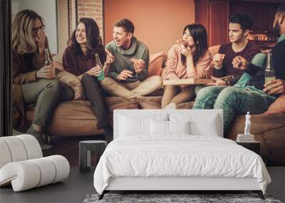 group of multi ethnic young friends eating pizza in home interior Wall mural