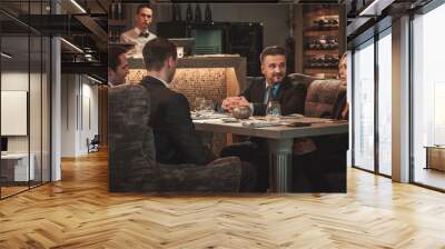 Group of successful business people discussing during business dinner in restaurant Wall mural