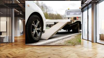 loading broken car on a tow truck on a roadside Wall mural