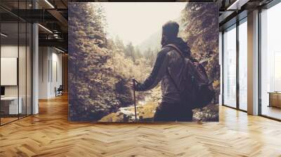 man with hiking equipment walking in mountain forest Wall mural