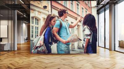 Multi ethnic friends tourists with map in old city Wall mural