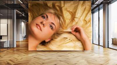 Portrait of a lovely beautiful blond girl lying in a bed Wall mural