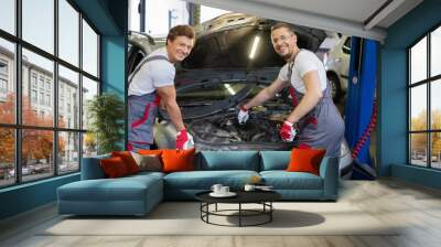 Two cheerful mechanic fixing car in a workshop Wall mural