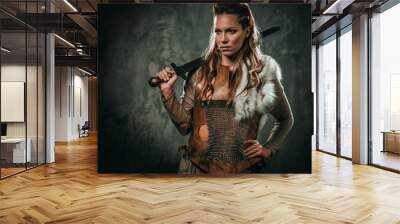 Viking woman with cold weapon in a traditional warrior clothes Wall mural