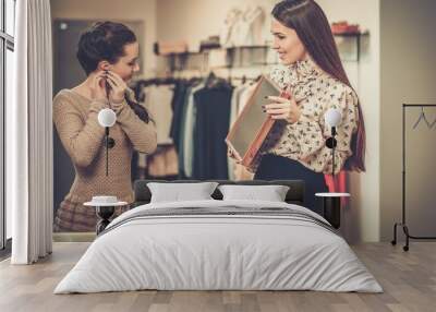 Young woman choosing jewellery with shop assistant  help Wall mural