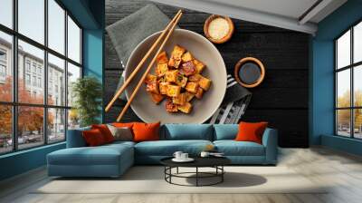 Fried tofu with sesame seeds and spices on black background. Wall mural