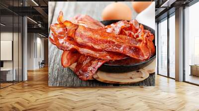 Hot fried bacon pieces in a cast iron skillet.top view Wall mural