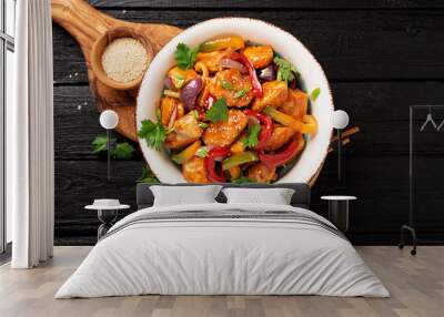 Stir fry with chicken, vegetables, soy sauce and sesame on black wooden background.  Wall mural