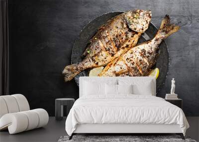 Tasty grilled fish dorado with  lemon on kitchen table. Wall mural