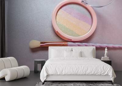 rainbow highlighter and cute twisted makeup brush close-up Wall mural