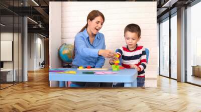 Toddler boy in child occupational therapy session doing sensory playful exercises with her therapist. Wall mural