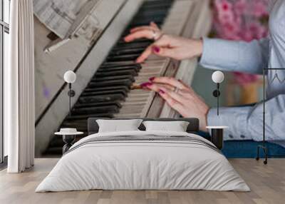 Beautiful white piano in the interior. Female hands play the piano Wall mural