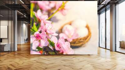 Spring blossom, Easter concept, miniature bunny, flowering tree close-up and copy space. Pink natural texture of natural flowering tree. Easter egg and branches of blossoming on an table.. Wall mural