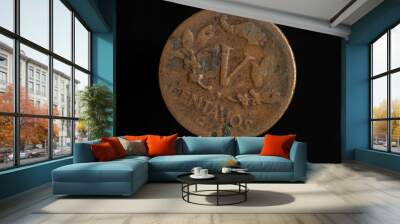 Very old copper Colombian coin, isolated on black background Wall mural