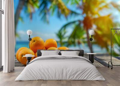 Exotic orange fruits on wooden surface with blurred sand beach, ocean or sea water waves and palm trees in the background. Summer holiday or vacation paradise island,Caribbean tourism wallpaper banner Wall mural