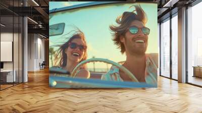 Happy young couple, smiling man and woman driving in retro vintage convertible cabriolet car on summer holiday or vacation. Freedom, laughing, cheerful, journey, trip, wearing sunglasses Wall mural