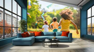 Rearview of happy joyful diverse boys and girls, kids playing outdoors, running and flying kite in the sunny spring or summer grass park. Leisure childhood activity, friends enjoy nature meadow field Wall mural