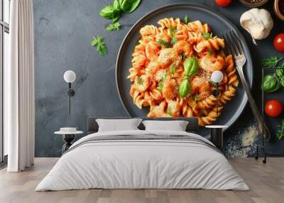 Top view or above shot of an Italian pasta meal with the red ripe tomato vegetable sauce on a dish or a plate on a gray table. Tasty macaroni with parmesan, bolognese lunch in a kitchen indoors Wall mural