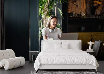 Young woman working remotely from caffe Wall mural