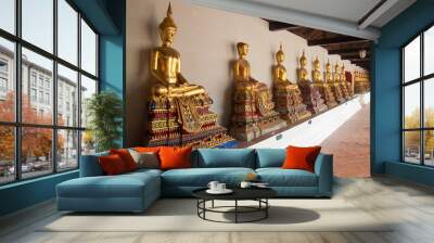 Row of Buddha statue with one broken head  in a temple in Thaila Wall mural