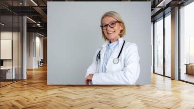 Happy female doctor holding crossed arms isolated Wall mural