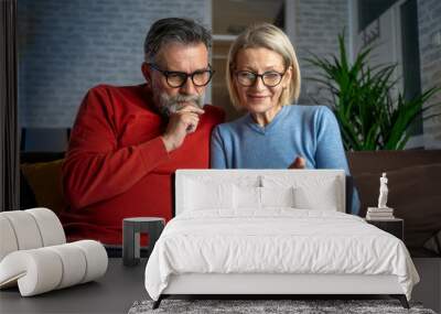 Laptop, budget and happy couple in living room for retirement, vacation and planning at home. Senior man, woman and together on computer for finance, money and savings account for holiday with joy Wall mural