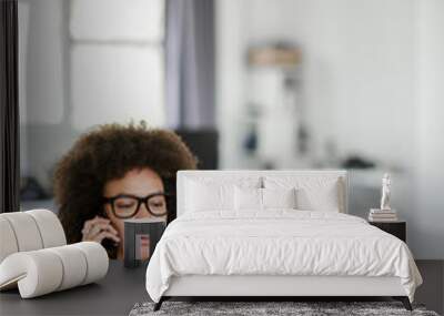 charming mixed race businesswoman dressed casual using smart phone and laptop at the same time while Wall mural