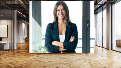 Beautiful young business woman standing while smiling looking at camera in the office. Wall mural