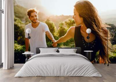 Beautiful young couple enjoying nature at mountain peak. Wall mural