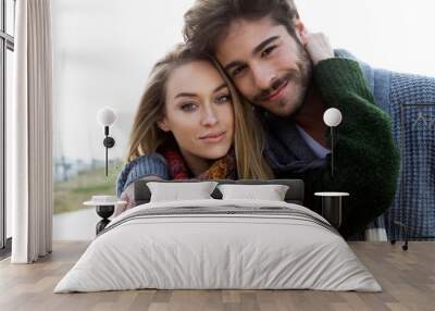 beautiful young couple in love in a cold winter on the beach. Wall mural