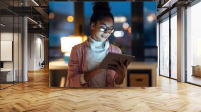 Beautiful young entrepreneur woman using her digital tablet standing in the office. Wall mural