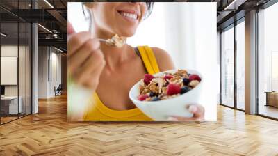 Beautiful young woman eating cereals and fruits at home. Wall mural