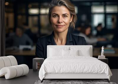 Confident executive woman posing in front of the camera with her arms crossed, behind her colleagues working in a modern office. Generative AI Wall mural