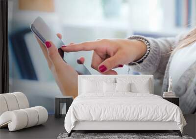 Female hands holding smartphone at home. Wall mural