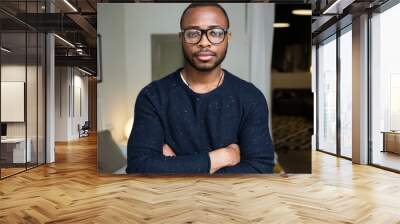 handsome young black man looking at camera at home. Wall mural