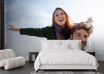 happy young couple enjoying the day in a cold winter on the beach. Wall mural