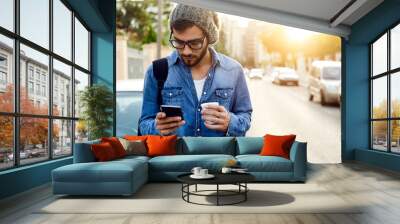 modern young man with mobile phone in the street. Wall mural