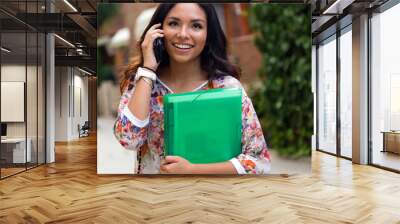 Pretty student girl talking on the phone. Wall mural