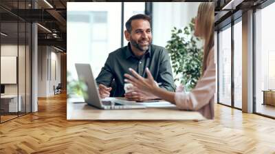 Smart business people working together with laptop while talking in the coworking place. Wall mural