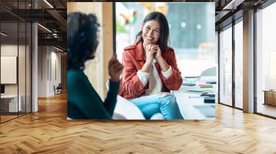 Smart business people working together with laptop while talking in the coworking place. Wall mural