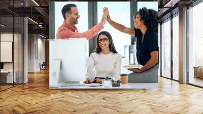 Successful business multiage team celebrating standing around table in the coworking space. Wall mural