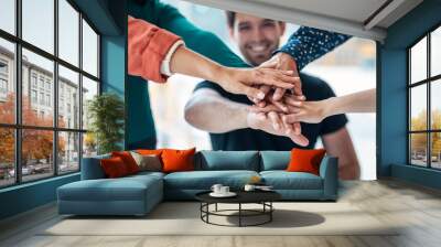 Successful smart business team celebrating good job while holding up their right hands on coworking place. Wall mural