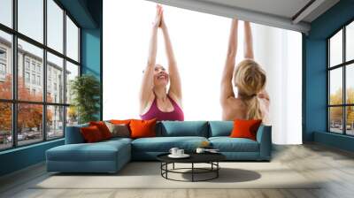 Two pretty young women practicing yoga at home. Wall mural