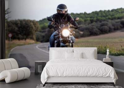 Young man biker having fun driving the empty highway on a motorcycle tour journey. Wall mural