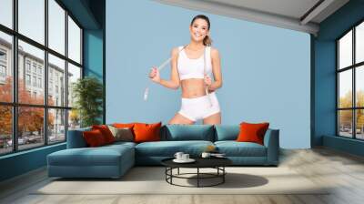 Active happy fit girl with centimeter. Wall mural