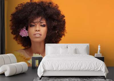 Beauty afro woman with fresh flowers. Wall mural