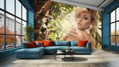 Blonde sensual girl over palm trees. Wall mural