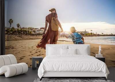 Family holiday on Tenerife, Spain. Mother with son walking on the sandy beach. Positive human emotions, active lifestyles. Wall mural