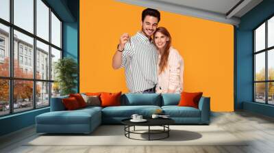 Happy couple with keys to new home. Wall mural