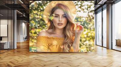 Happy girl with freckles posing in sunny garden. Wall mural